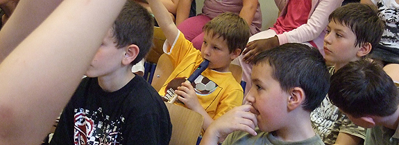 Kinder, dritte Klasse mit Flöten und Finger aufzeigend